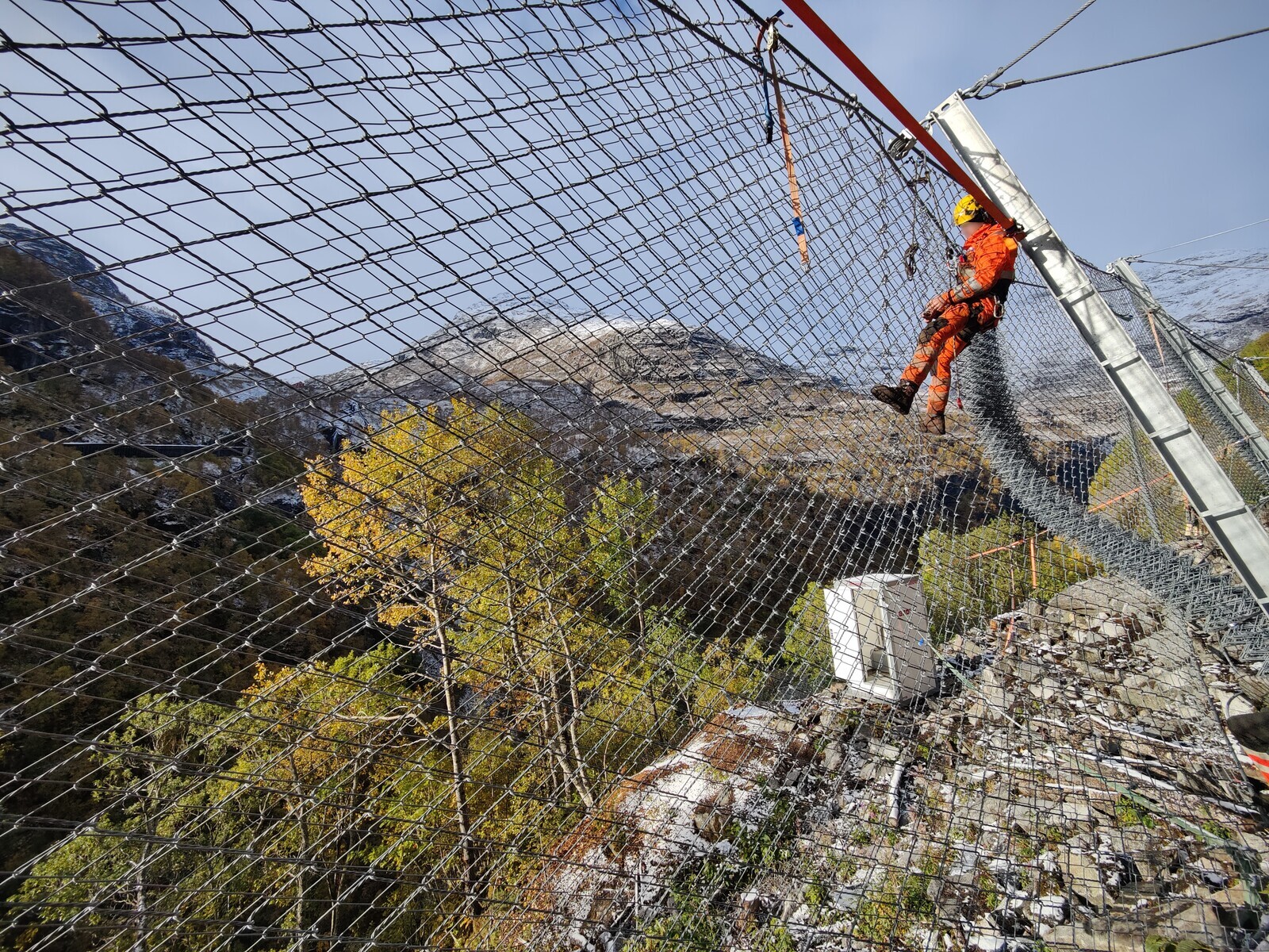 Securing the net to the rockfall barrier